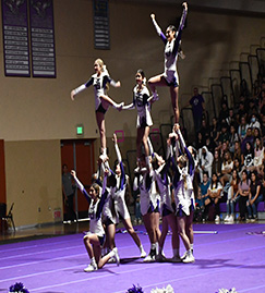 cheerleaders in gym forming a human pyramid