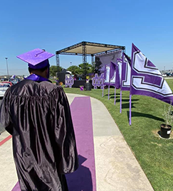 Male student walking the purple carpet during graduation