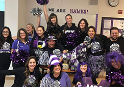 Group of staff members in school spirit attire posing together